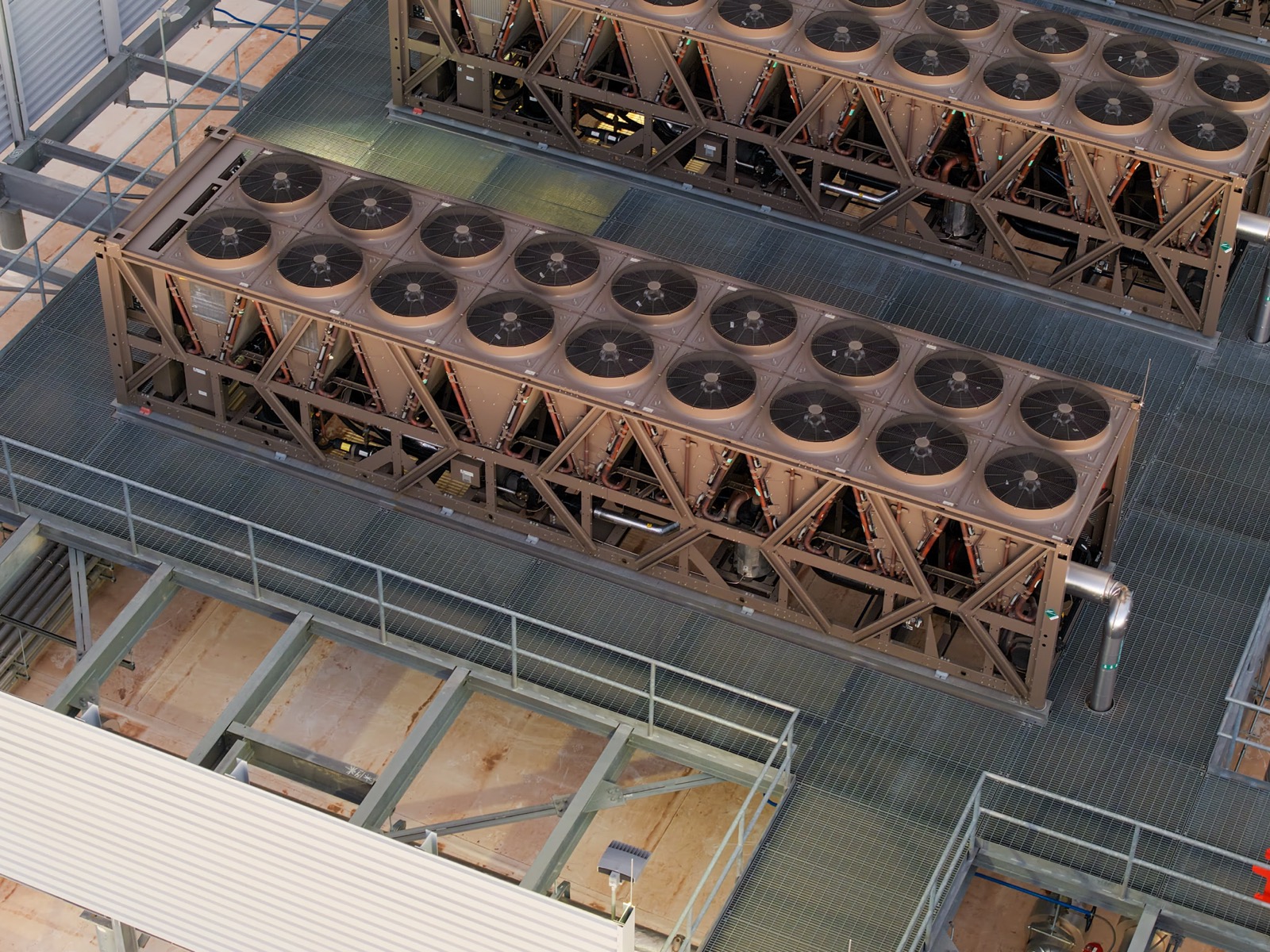 A large industrial cooling tower beside a data center building, with fans and louvered sides