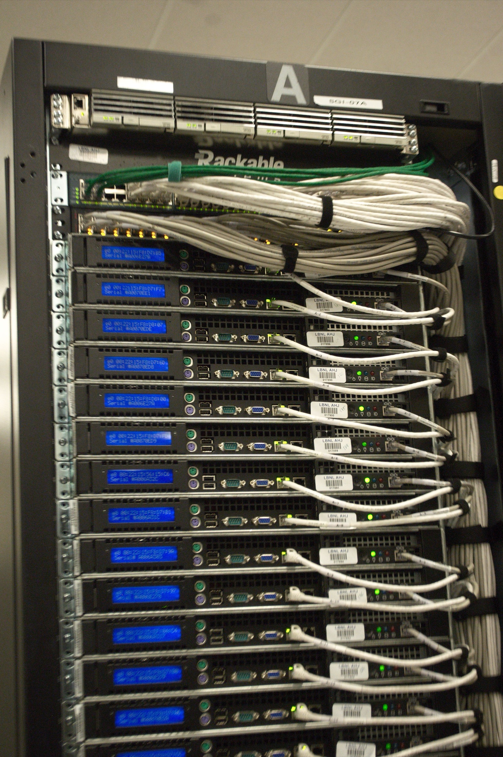 Close-up of the rear of a server rack at the NERSC data center, showing dense cabling and power connections
